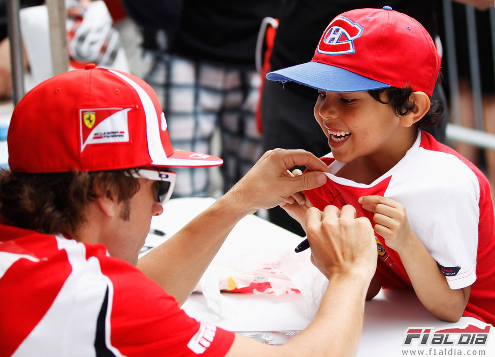 Fernando Alonso firma la camiseta de un niño en Canadá 2011