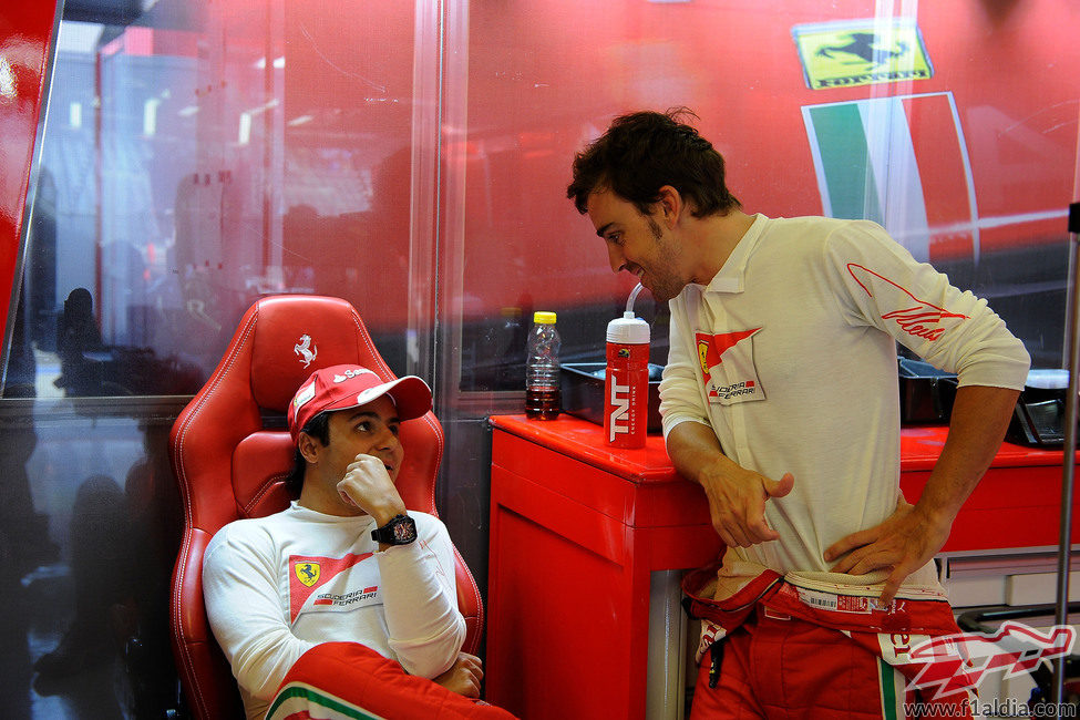 Fernando Alonso y Felipe Massa charlan en el box de Ferrari