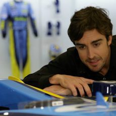 Alonso mira uno de sus coches ganadores