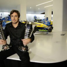 Fernando Alonso sostiene los trofeos de sus dos títulos mundiales