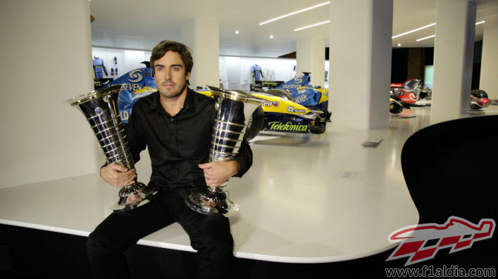 Fernando Alonso sostiene los trofeos de sus dos títulos mundiales