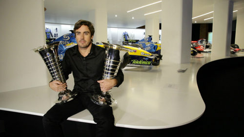 Fernando Alonso sostiene los trofeos de sus dos títulos mundiales