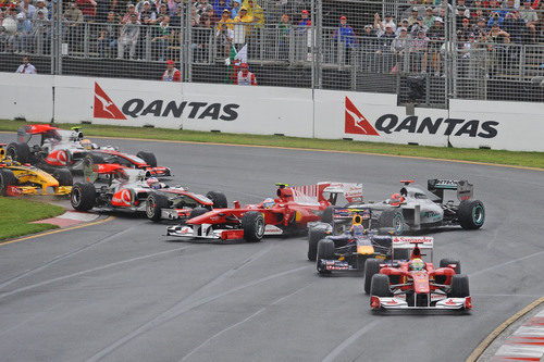 Fernando Alonso es tocado por Jenson Button en el primera curva